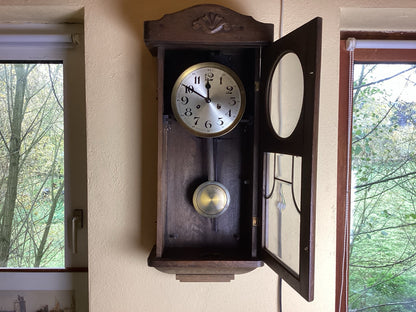 Holzregulator aus der Zeit um 1930 mit geöffneter verglaster Tür, Werk und Pendel sichtbar