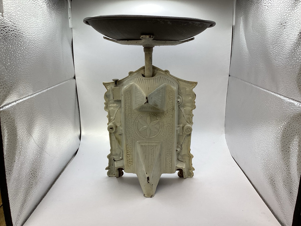 Rückansicht der alten Haushaltswaage mit ornamentiertem Metallgehäuse und aufgelegter Waagschale