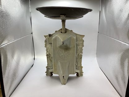 Rückansicht der alten Haushaltswaage mit ornamentiertem Metallgehäuse und aufgelegter Waagschale
