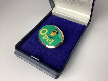 Opel Brosche im geöffneten Etui mit blau-violetter Samteinlage, Schrägansicht