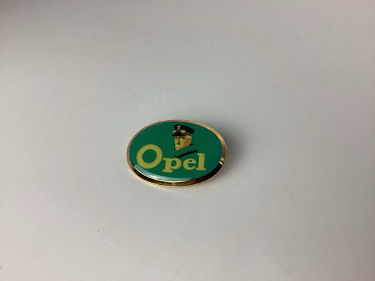 Ovale grün-goldene Opel Brosche mit Schriftzug und Figurenmotiv, Vorderseite