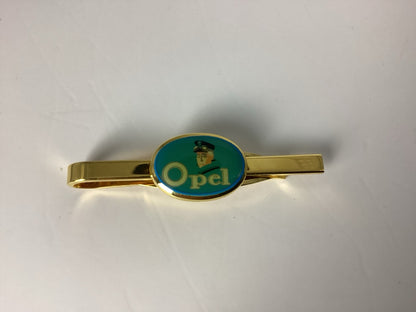 Nahansicht des türkisgrünen ovalen Opel-Motivs mit stilisierter Figur an goldfarbener Krawattenklammer