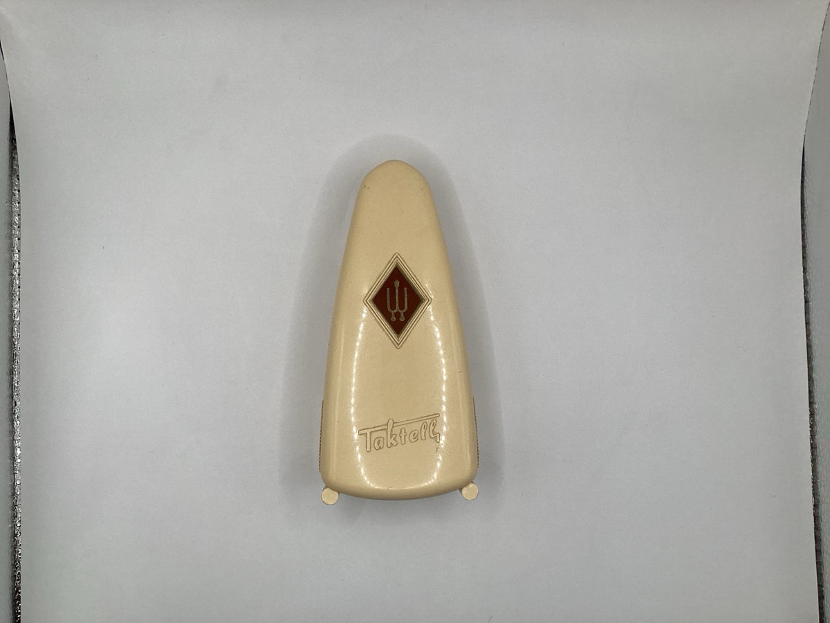 Wittner Taktell Piccolo, cremefarbener Gehäusedeckel mit rotem Rautenlogo und Schriftzug